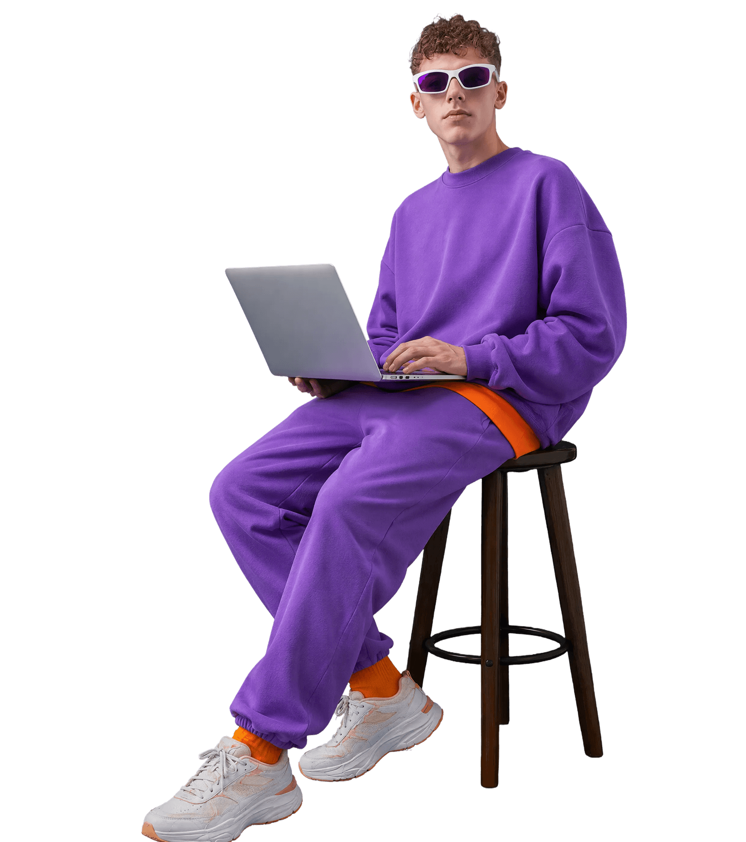 Creator with laptop seated against a purple backdrop